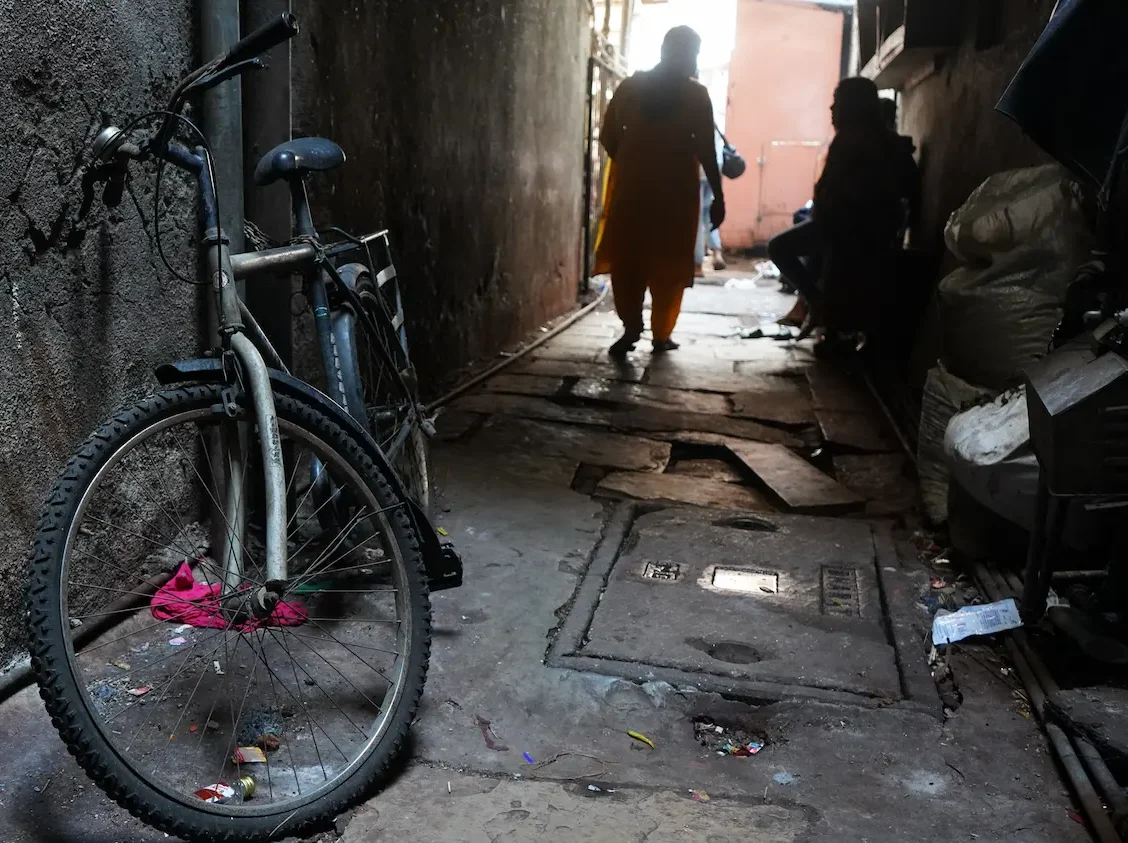 photo of a back alley with a cycle and two ladies